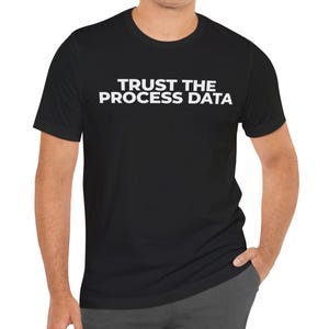 Könnte beinhalten: Schwarzes T-Shirt mit dem weißen Text "TRUST THE PROCESS DATA" auf der Brust. Das kurzärmelige Shirt ist aus einem weichen Material gefertigt und eignet sich für Freizeitkleidung. Das Shirt hat eine schwarze Farbe.