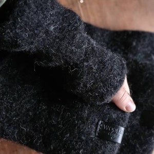 May include: Black wool fingerless gloves with a leather patch that says "Woolie Days".