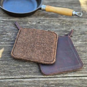 Agarradera de fieltro y cuero, fieltrada y cosida a mano.