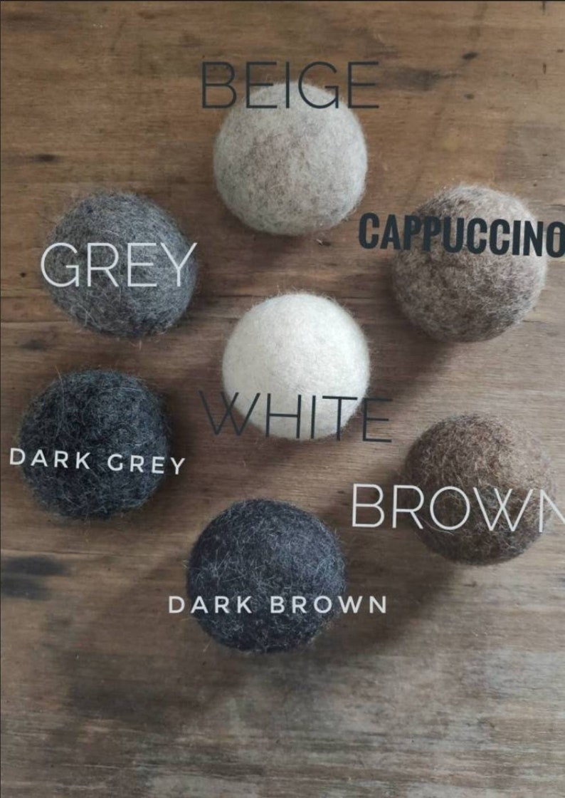 Pode incluir: Conjunto de bolas de feltro em v&aacute;rias cores, incluindo bege, cinza, branco, cappuccino, cinza escuro, marrom e marrom escuro.