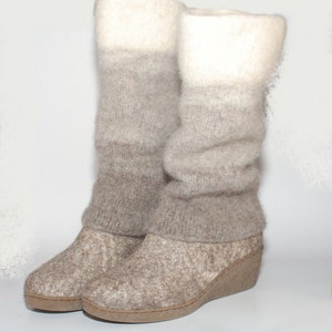 May include: A pair of gray and white knit boots with a wedge heel. The boots are made of a soft, fuzzy material and have a slouchy look.