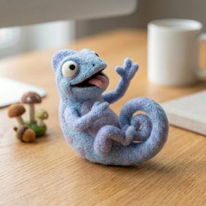 May include: A needle-felted light blue chameleon figurine with a curled tail, one raised arm, and an open mouth showing a pink tongue. Beside it sits a small cluster of three felted mushrooms in shades of brown, tan, and green.