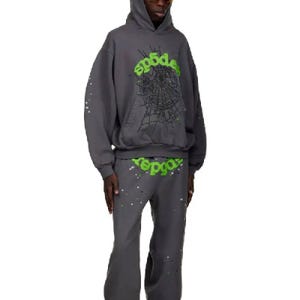 May include: A dark gray hoodie and matching pants set. The hoodie features a green spiderweb design and the word "sp5der" in green. The pants also have the word "sp5der" in green. Both pieces have white and silver paint splatter.