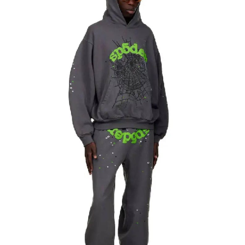 May include: A dark gray hoodie and matching pants set. The hoodie features a green spiderweb design and the word "sp5der" in green. The pants also have the word "sp5der" in green. Both pieces have white and silver paint splatter.