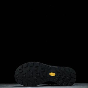 May include: Black hiking boot sole with a textured pattern for grip. The sole features a yellow Vibram logo. The image is set against a black background, highlighting the boot's design.