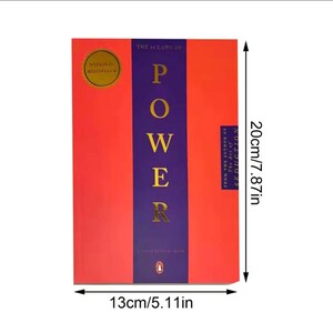 May include: A hardback book titled "The 48 Laws of Power", measuring 13cm wide and 20cm tall. The cover is red with a purple central stripe, displaying the title in gold. A gold seal indicates "National Bestseller".