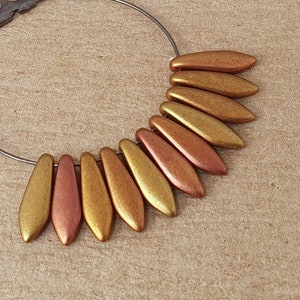 May include: A hoop earring with a row of gold and copper coloured teardrop shaped beads.