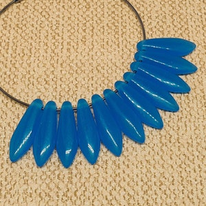 May include: A pair of hoop earrings with a silver hoop and a row of light blue teardrop-shaped beads.