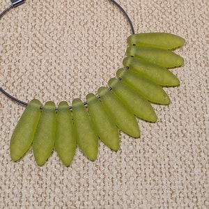 May include: A silver hoop earring with a row of light green glass beads in a teardrop shape.