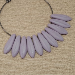 May include: A silver hoop earring with a row of lavender-coloured teardrop-shaped beads.