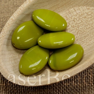 May include: Five oval-shaped green glass beads in a wooden bowl. The beads are smooth and glossy.