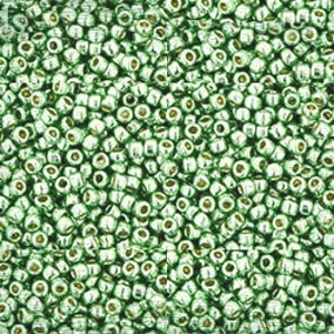 May include: A close-up image of a large quantity of small, round, green glass beads. The beads have a metallic sheen and are arranged in a random pattern.