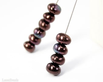 May include: A close-up of a strand of dark brown iridescent glass beads strung on a silver wire. The beads are round and have a smooth, shiny finish.