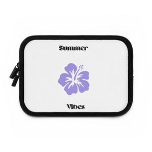 Può includere: Custodia bianca per laptop con bordo e cerniera neri. La custodia presenta le parole "Summer Vibes" in testo nero, con un fiore di ibisco viola al centro.