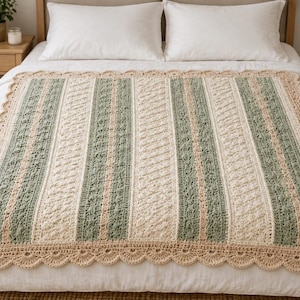 May include: A rectangular crochet blanket featuring vertical stripes in sage green, cream, and soft peach. The design incorporates varied textured stitch patterns, including cables and bobbles, finished with a wide, scalloped shell-stitch border.