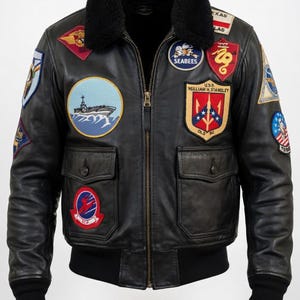 Puede incluir: Chaqueta bomber de cuero negro con cuello de piel sintética negra y múltiples parches bordados. Cuenta con cremallera frontal, dos bolsillos delanteros y dobladillo y puños acanalados. Los parches incluyen insignias militares y navales.