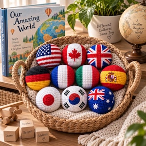 Puede incluir: Una cesta tejida llena de nueve bolas redondas de ganchillo, cada una con un diseño de bandera nacional diferente. Las banderas incluyen las de Estados Unidos, Canadá, Reino Unido, Alemania, Francia, Italia, España, Japón, Corea del Sur y Australia.