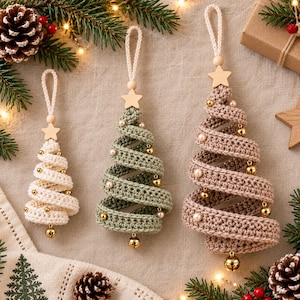 May include: Three spiral-shaped Christmas tree ornaments made of crocheted yarn in cream, sage green, and dusty rose. Each tree features a wooden star at the top, a hanging loop, and is decorated with small gold jingle bells and white beads.