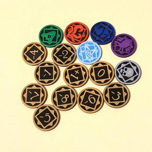 Pode incluir: Uma coleção de fichas de jogo de madeira com vários símbolos e números. As fichas têm uma base castanha clara com números e símbolos pretos. Algumas fichas têm símbolos coloridos em verde, vermelho, azul, roxo e azul claro.
