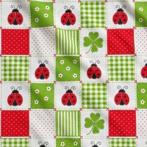 May include: A fabric pattern featuring a grid of alternating squares. The design includes red ladybugs on white, green and white gingham, red with white polka dots, green with white flowers, green stripes, and green four-leaf clovers on white.