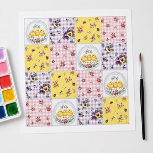 May include: A square sheet of paper featuring a grid of sixteen decorative patterns, including illustrations of yellow chicks, purple pansies, pink gingham with roses, and yellow backgrounds with bees, accompanied by a watercolour set and a paintbrush.