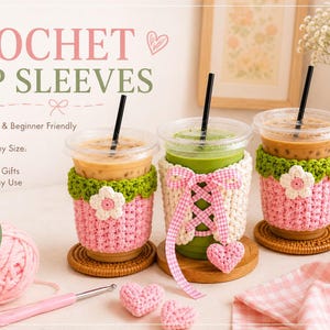 May include: Three crochet cup sleeves in pink, white, and green, each featuring floral or ribbon accents. The image includes text reading CROCHET CUP SLEEVES, a pink yarn ball, a crochet hook, and two small pink crochet hearts on a light surface.