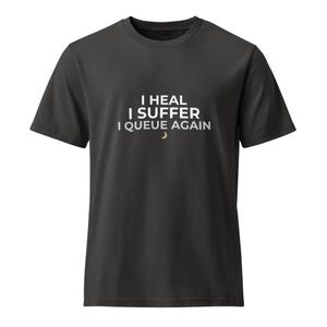 Puede incluir: Camiseta gris oscuro con el texto blanco "I HEAL I SUFFER I QUEUE AGAIN" y un pequeño gráfico de media luna. La camiseta tiene cuello redondo y mangas cortas.