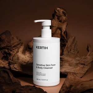 Könnte beinhalten: Weiße Flasche Kertih Sensitive Skin Face & Body Cleanser mit einem Pumpspender. Die Flasche hat schwarzen Text und enthält 390 ml. Der Hintergrund zeigt Holzstücke vor einem braunen Hintergrund.