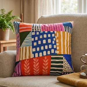 May include: A square throw pillow featuring a vibrant patchwork design with various abstract patterns including blue squares, orange leaf motifs, yellow stripes, and pink sections. The colorful fabric displays a mix of geometric and organic shapes.