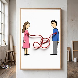 May include: A framed wall art print featuring a cartoon illustration of a person in a pink dress and a person in a blue shirt and gray pants. A single red string emerges from the chest of each figure, looping and knotting in the center space.