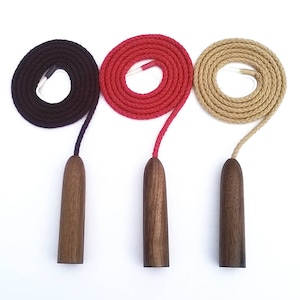 May include: Three wooden cord pulls with different coloured cords. The cords are black, red and beige. The wooden pulls are all the same shape and size.
