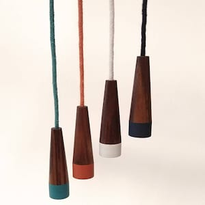 May include: Five wooden light pull switch cords with different coloured ends. The cords are teal, orange, white, navy blue, and teal.