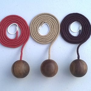 May include: Three wooden ball light pull chains with red, beige, and brown cords.
