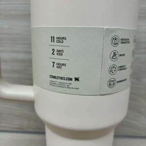 Puede incluir: Un vaso t&eacute;rmico rosa claro con asa. La etiqueta indica que mantiene las bebidas fr&iacute;as durante 11 horas, heladas durante 2 d&iacute;as y calientes durante 7 horas. Caracter&iacute;sticas: acero inoxidable reciclado, sin BPA y apto para lavavajillas.