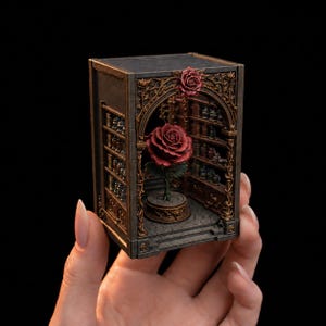 May include: A miniature diorama box featuring a dark gray and bronze-toned structure with an arched entryway. Inside, a single large red rose sits on a circular pedestal, surrounded by shelves filled with tiny jars and bottles on the side walls.