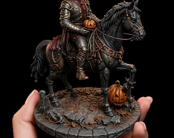 May include: A detailed figurine of a headless horseman in dark metallic armor riding a black horse. The figure holds a small orange jack-o'-lantern, while a larger carved pumpkin sits on the stone-textured base near the horse's front hoof.