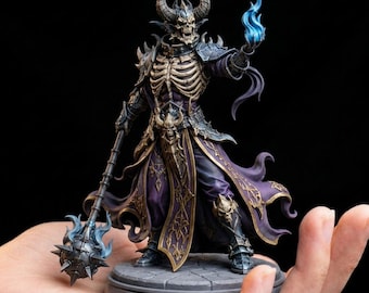 May include: A detailed figurine of a skeletal sorcerer with horns, clad in purple and gold robes, holding a staff with a spiked head and a blue flame. The figure is posed on a circular base, showcasing intricate armor and skeletal details.