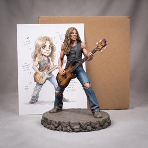 May include: A detailed figurine of a long-haired musician playing a sunburst bass guitar, wearing a dark tank top and distressed blue jeans with a knee hole. The figure stands on a textured stone-like base, accompanied by a sketch print.