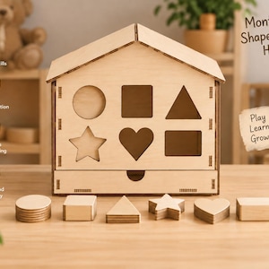 May include: A light-colored wooden house-shaped shape sorter toy with a drawer at the base. The front panel features cutouts for a circle, square, triangle, star, heart, and rectangle. Six matching wooden shapes are arranged in front of the house.