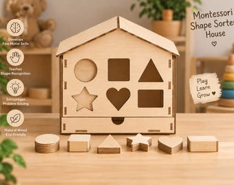 May include: A light-colored wooden house-shaped shape sorter toy with a drawer at the base. The front panel features cutouts for a circle, square, triangle, star, heart, and rectangle. Six matching wooden shapes are arranged in front of the house.