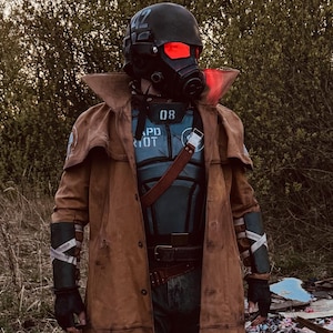 May include: A full-body costume featuring a long brown duster coat, a dark gray chest plate with the number 08, and a black tactical helmet with glowing red lenses. The outfit includes dark forearm guards, black gloves, and dark trousers.