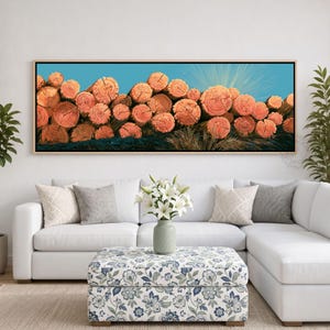 May include: A panoramic wall art print featuring a large stack of cylindrical orange-toned logs against a bright blue sky. The logs are arranged in a dense, horizontal pile, showcasing the circular grain patterns on their cut ends.