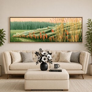 May include: A rectangular landscape painting in a light wood frame depicting a stack of light green logs with orange-toned ends resting in a grassy field. A dense forest of green trees stands in the background under a soft peach-colored sky.