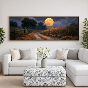 May include: A panoramic wall art print featuring a night landscape with a large yellow full moon, a dirt path winding through a cornfield, a wooden fence, and several pumpkins on the ground, all enclosed in a thin light-colored wooden frame.