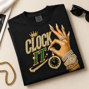 Puede incluir: Una camiseta negra con un estampado gráfico de una mano con uñas doradas largas, que lleva varias pulseras con incrustaciones de diamantes y un reloj. El texto CLOCK IT aparece en dorado y verde, junto a una corona y un reloj de bolsillo.