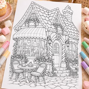 May include: A black and white colouring page illustration of a bakery shop with a shingled roof, a large storefront window displaying pastries, a front door, and outdoor seating with two chairs and a small round table on a stone patio.