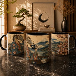 May include: Three ceramic mugs featuring a dragon wearing a kimono and drinking tea, with a landscape of Mount Fuji and cherry blossoms. The mugs have black handles and rims, displaying detailed Japanese-style art with text in vertical columns.
