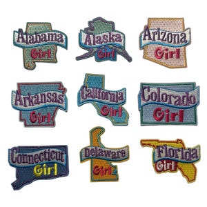 May include: Embroidered patches featuring state outlines with the state name and the word "Girl". Patches include Alabama, Alaska, Arizona, Arkansas, California, Colorado, Connecticut, Delaware, and Florida. Each patch has a unique color scheme.