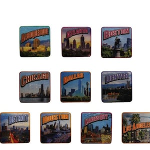 May include: A collection of nine square magnets featuring cityscapes. Each magnet displays a different city name: Albuquerque, Atlanta, Boston, Chicago, Dallas, Denver, Detroit, Houston, Kansas City, and Los Angeles. The magnets have a vintage, travel-themed aesthetic.