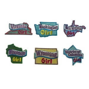 May include: Embroidered patches featuring state outlines with the state name and the word "Girl". Patches include Virginia, Washington, West Virginia, Wisconsin, Wyoming, and District of Columbia. Each patch has a unique color scheme.